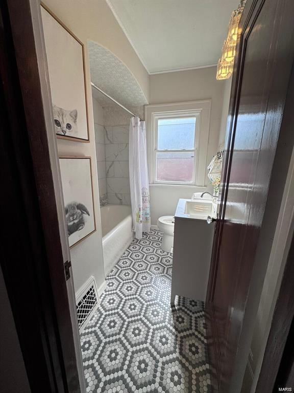 bathroom featuring visible vents, toilet, tile patterned flooring, shower / bath combo with shower curtain, and vanity