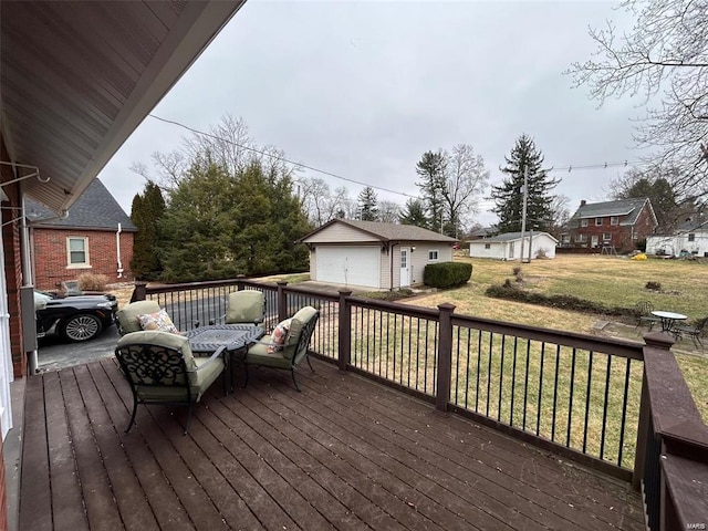 wooden terrace featuring a yard, a residential view, a detached garage, and an outbuilding