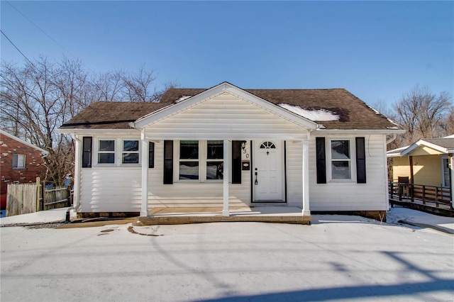 bungalow-style house featuring roof with shingles and fence