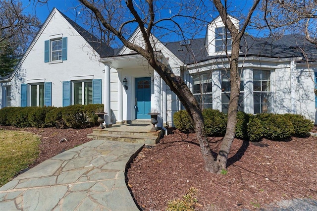 cape cod-style house featuring brick siding