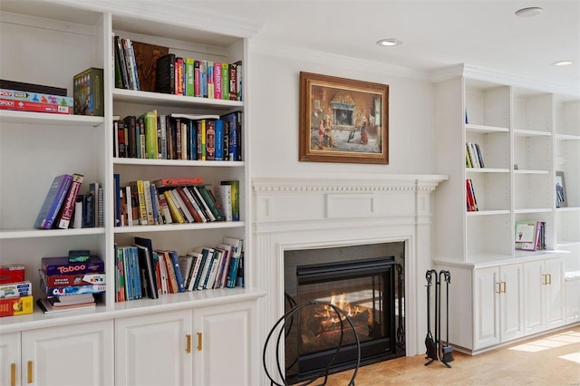 details with recessed lighting, ornamental molding, and a glass covered fireplace