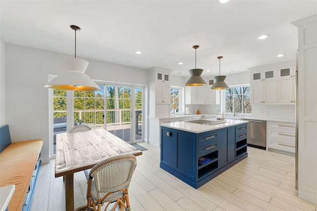 kitchen with blue cabinets, electric cooktop, white cabinetry, light countertops, and stainless steel dishwasher