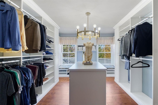 spacious closet featuring an inviting chandelier and wood finished floors