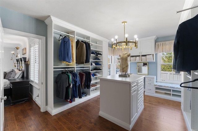 spacious closet featuring hardwood / wood-style flooring and an inviting chandelier