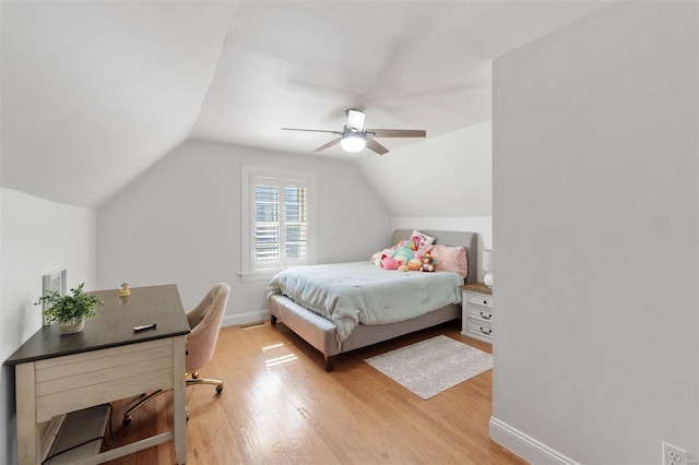 bedroom with light wood-style flooring, baseboards, vaulted ceiling, and a ceiling fan