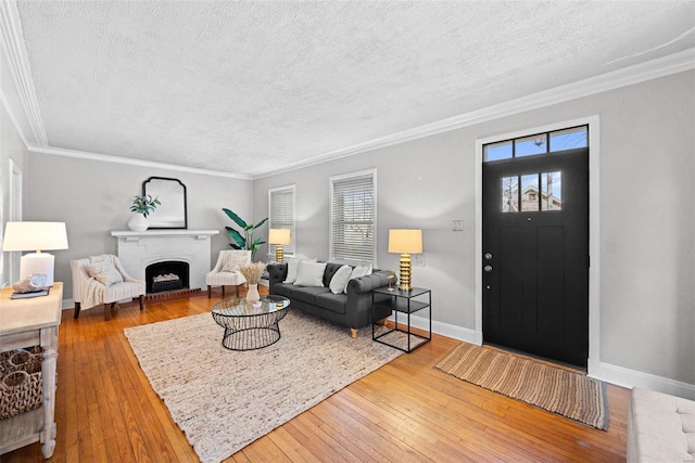 living area featuring a brick fireplace, wood-type flooring, and plenty of natural light