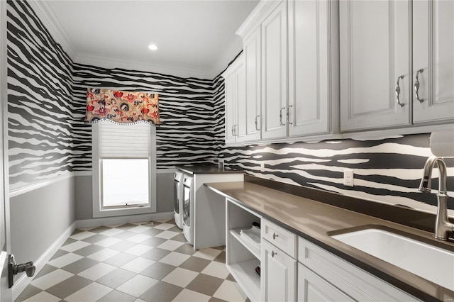 laundry room featuring a sink, baseboards, cabinet space, light floors, and washing machine and clothes dryer