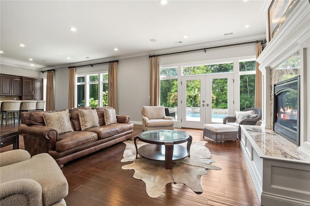 living room with ornamental molding, french doors, dark wood-style flooring, and a high end fireplace