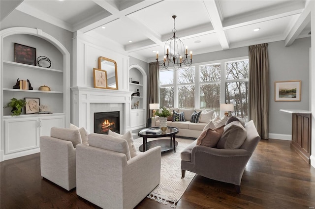 living room featuring built in features, dark wood finished floors, an inviting chandelier, a warm lit fireplace, and beamed ceiling