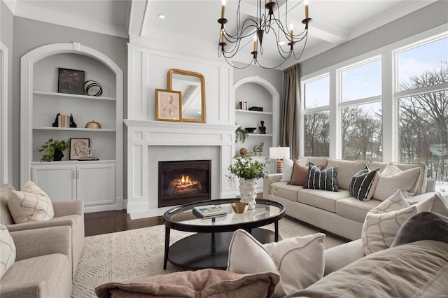 living area featuring built in features, beam ceiling, ornamental molding, a fireplace with flush hearth, and wood finished floors