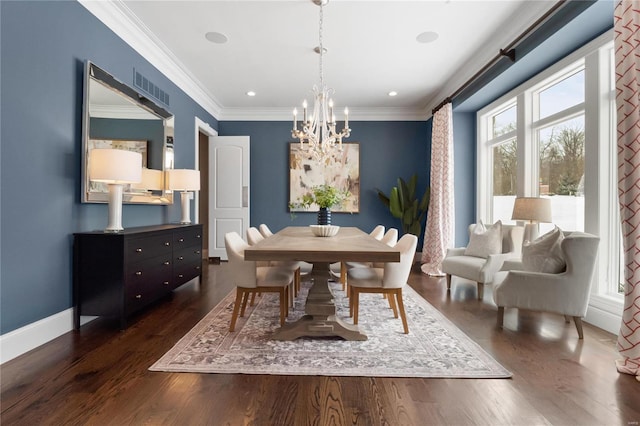 dining area featuring dark wood-style floors, a chandelier, ornamental molding, and baseboards