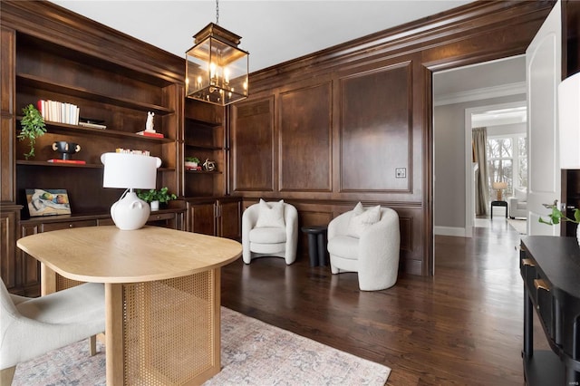 office with built in shelves, a decorative wall, ornamental molding, wood finished floors, and a chandelier