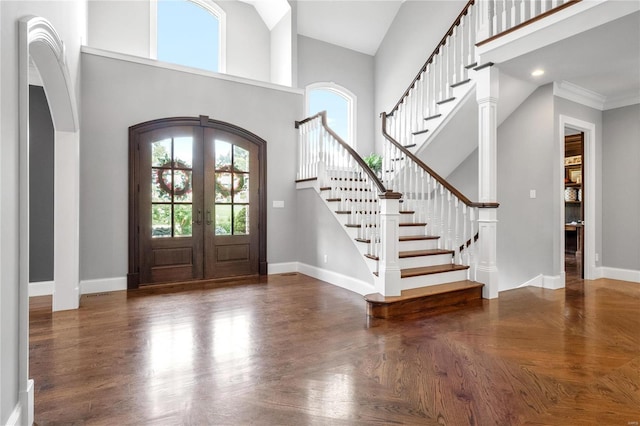 foyer entrance featuring french doors, a high ceiling, and baseboards