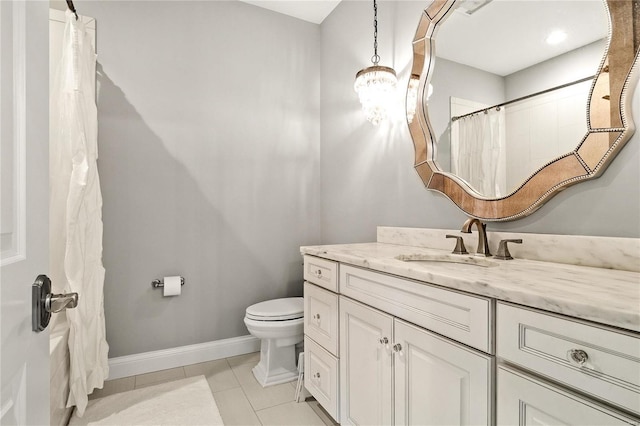 bathroom featuring vanity, tile patterned flooring, toilet, and baseboards