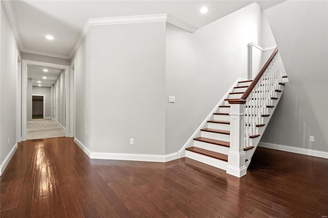 staircase featuring ornamental molding, baseboards, and wood finished floors