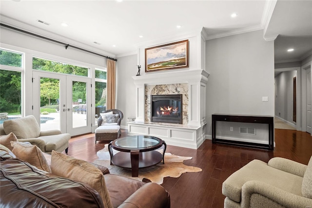 living room featuring dark wood-type flooring, a fireplace, visible vents, french doors, and crown molding