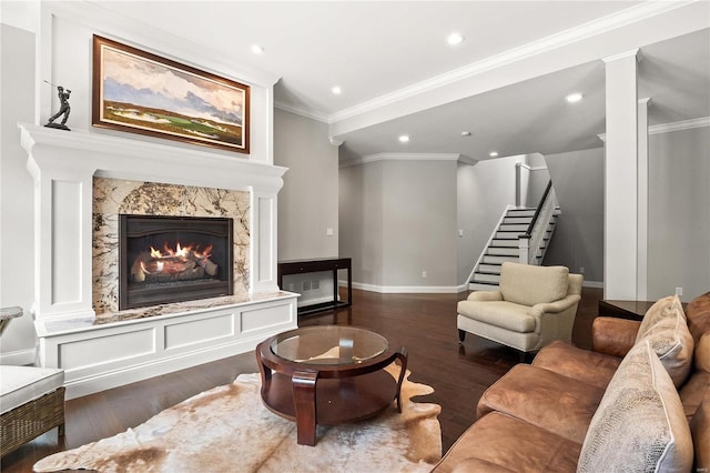 living area featuring dark wood-type flooring, crown molding, stairway, and a premium fireplace