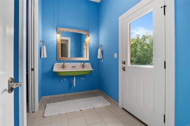 bathroom with tile patterned flooring, baseboards, and a sink