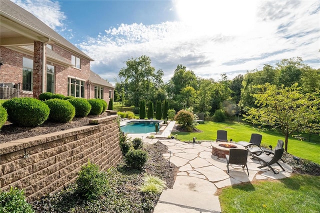 pool featuring a yard, a patio, and a fire pit