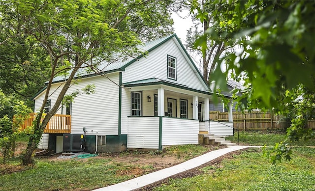 view of side of home featuring fence, metal roof, and a lawn