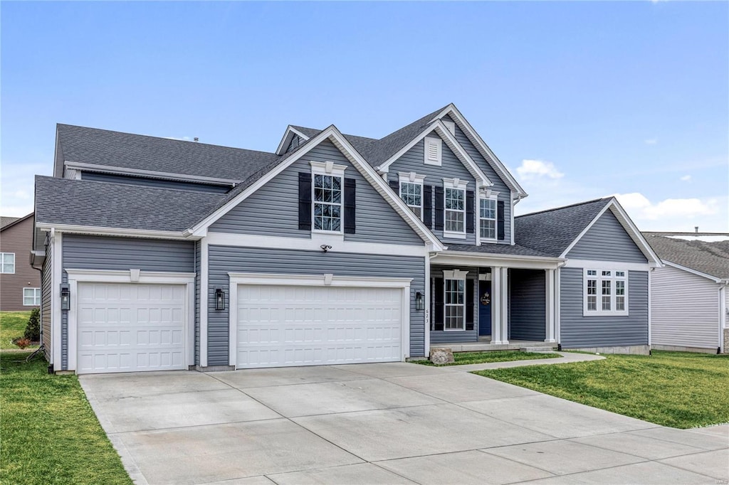 traditional-style house featuring a front lawn, concrete driveway, and roof with shingles