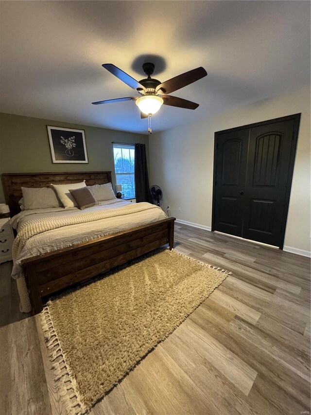 bedroom with a ceiling fan, baseboards, and wood finished floors