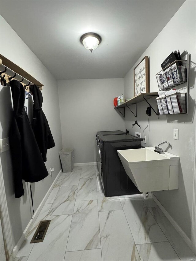 washroom featuring laundry area, visible vents, washer and clothes dryer, marble finish floor, and a sink