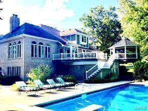 back of property featuring stairs, a chimney, and a gazebo