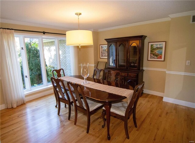 dining space with light wood-style flooring, baseboards, and crown molding