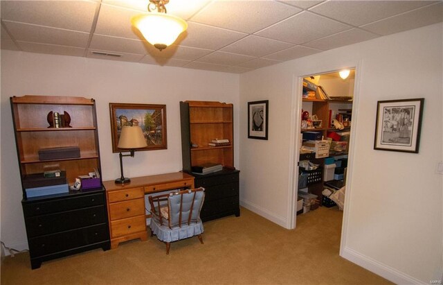 office space featuring a paneled ceiling, light colored carpet, visible vents, and baseboards