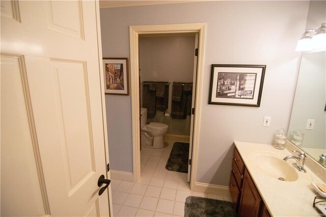 bathroom featuring toilet, baseboards, vanity, and tile patterned floors