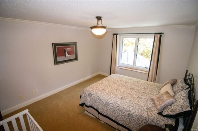 carpeted bedroom featuring ornamental molding and baseboards