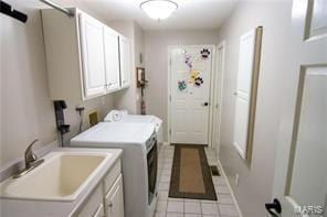 laundry area with a sink, light tile patterned floors, washing machine and clothes dryer, and cabinet space