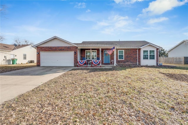 ranch-style house featuring brick siding, concrete driveway, an attached garage, a front yard, and fence