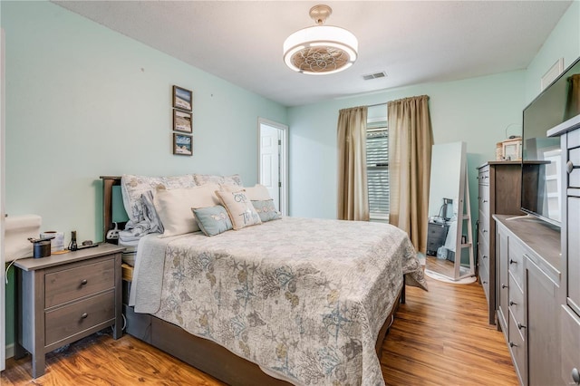 bedroom with visible vents and wood finished floors