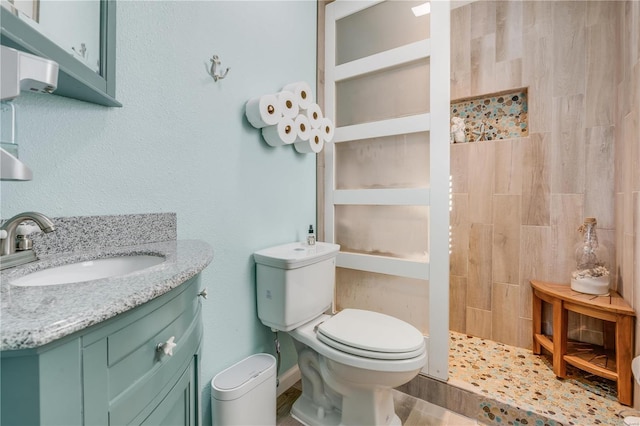 bathroom with toilet, a walk in shower, and vanity