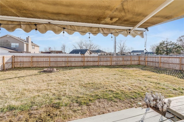 view of yard featuring a fenced backyard and a fire pit