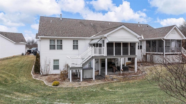 back of property featuring a deck, a shingled roof, a sunroom, a yard, and stairway