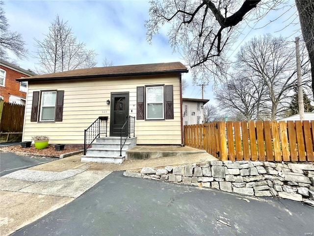 bungalow-style home featuring fence