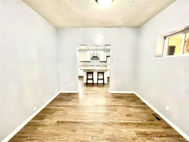 unfurnished dining area featuring visible vents, baseboards, and wood finished floors