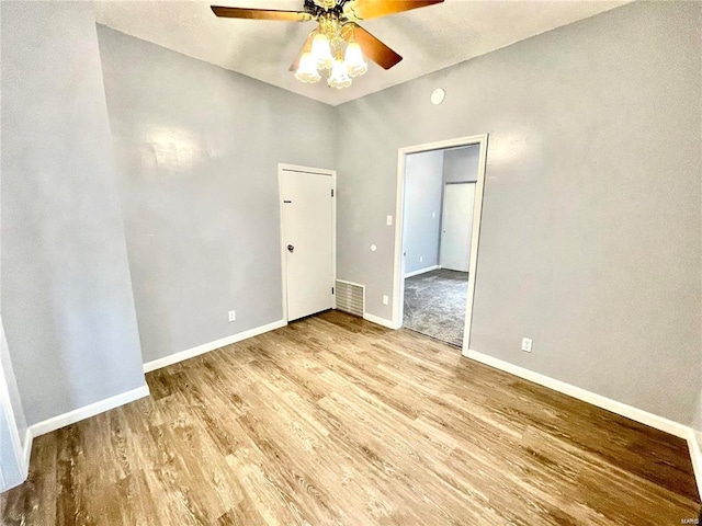 unfurnished room with ceiling fan, light wood-type flooring, visible vents, and baseboards