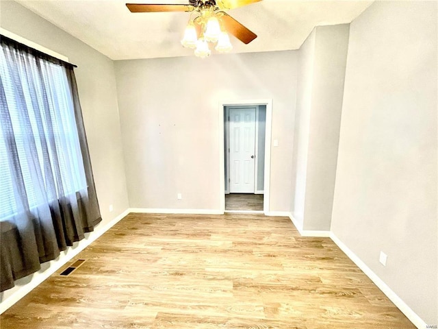 unfurnished room with light wood-type flooring, visible vents, plenty of natural light, and baseboards