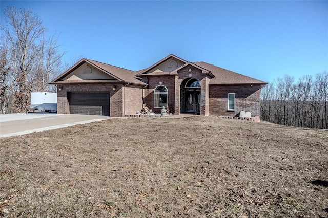 ranch-style house featuring concrete driveway, brick siding, and an attached garage