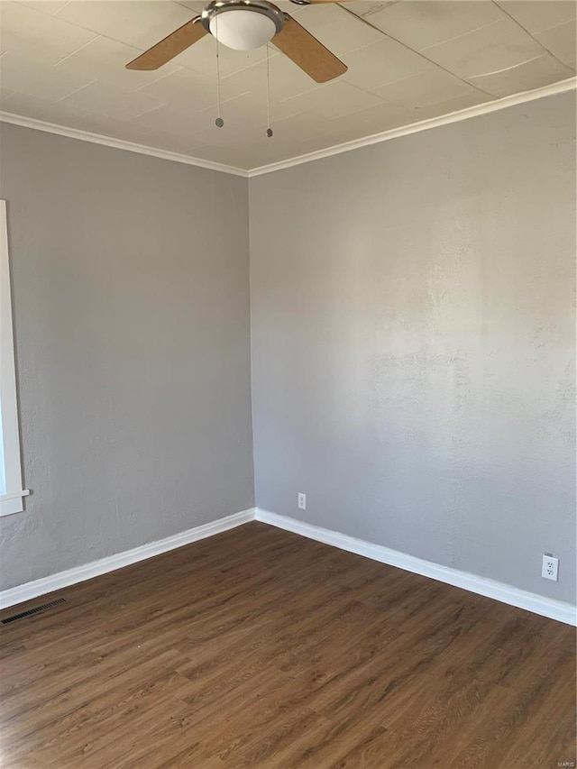 unfurnished room featuring a ceiling fan, baseboards, visible vents, dark wood-style floors, and crown molding