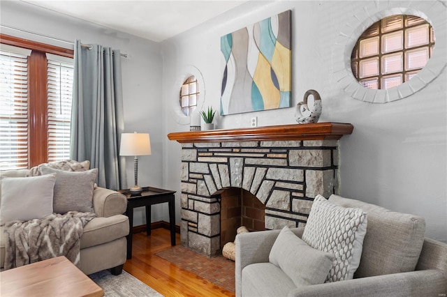 sitting room with a fireplace and wood finished floors