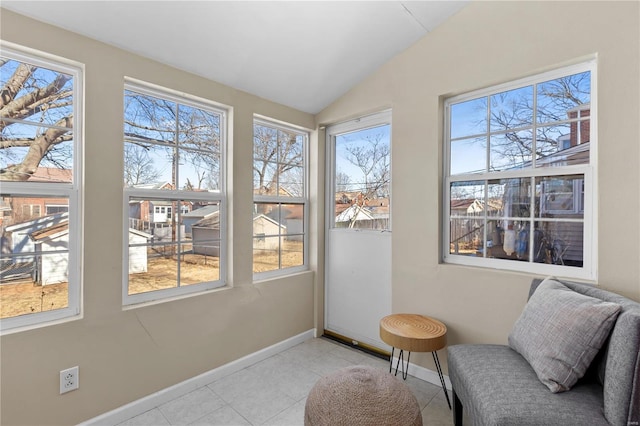 sitting room featuring lofted ceiling, light tile patterned floors, and baseboards