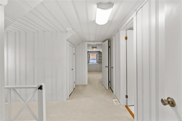 hallway featuring visible vents and light carpet