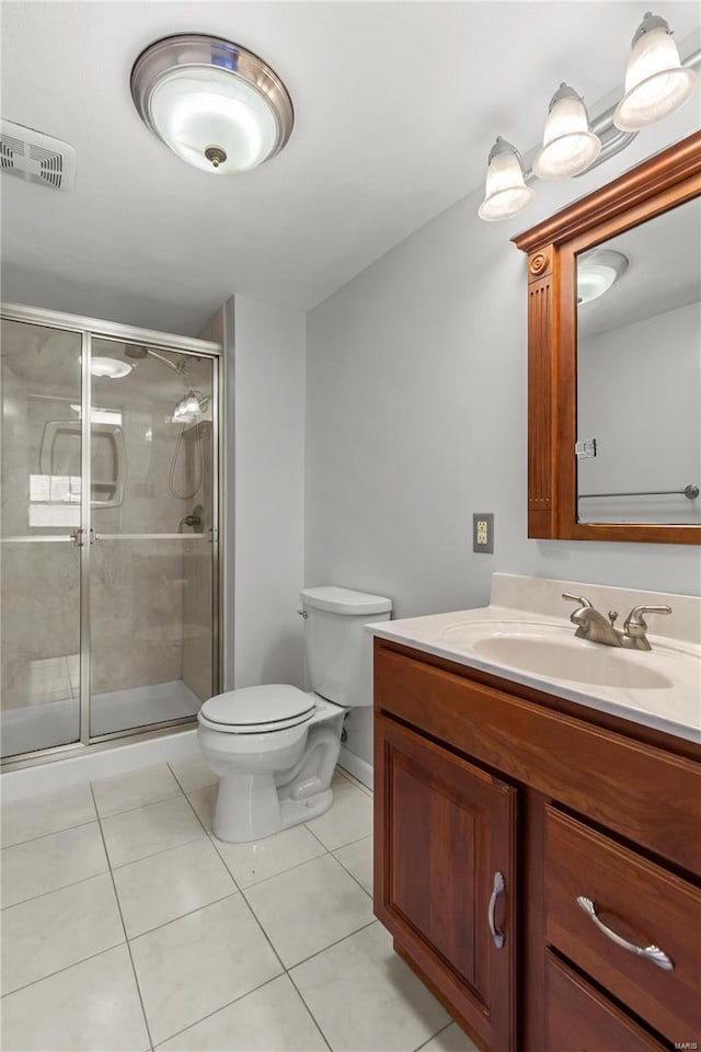 bathroom with toilet, visible vents, vanity, tile patterned floors, and a stall shower