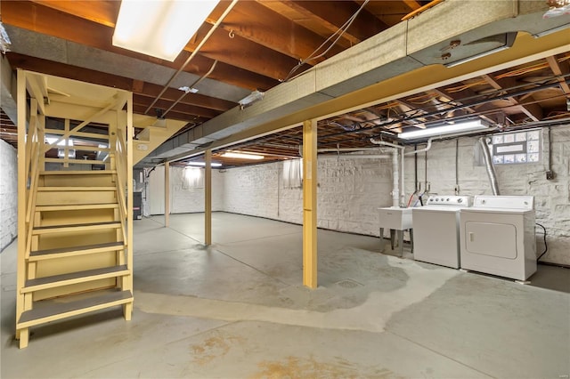 basement featuring stairs, a sink, and independent washer and dryer