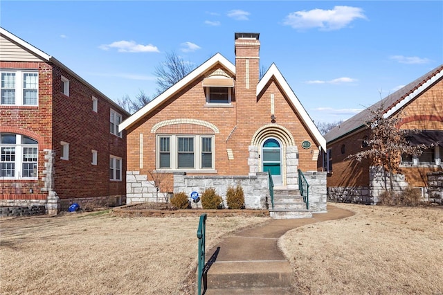 tudor-style house with brick siding and a chimney